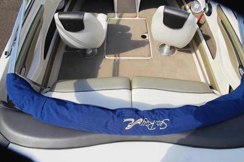 Slide: The Image of Interior of a 2006 Sea Ray 205 Sport boat with seating and blue cover. - 10
