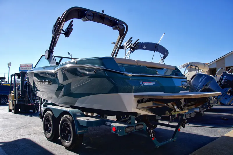 Slide: The Image of 2025 MasterCraft NXT20 boat on trailer, sunny day, rear view. - 2