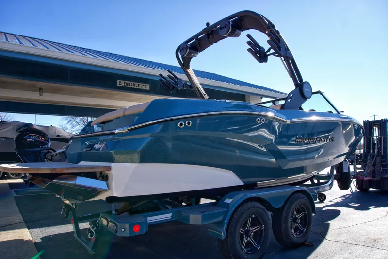 Slide: The Image of 2025 MasterCraft NXT20 boat on trailer, parked outdoors under a blue sky. - 4