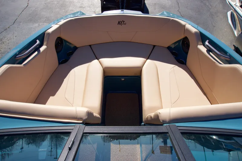 Slide: The Image of 2025 MasterCraft NXT20 boat interior with beige seating and teal accents. - 7