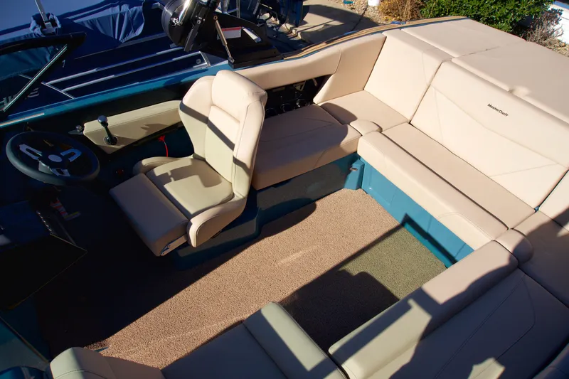 Slide: The Image of 2025 MasterCraft NXT20 boat interior with beige seating and blue accents. - 8