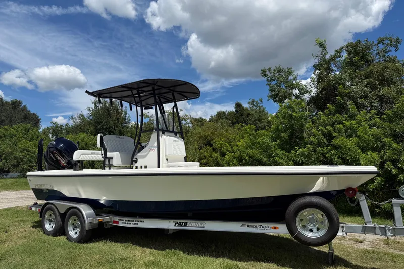 The Image of 2026 Pathfinder 2300 HPS boat on trailer, parked on grass under a cloudy sky. - 0
