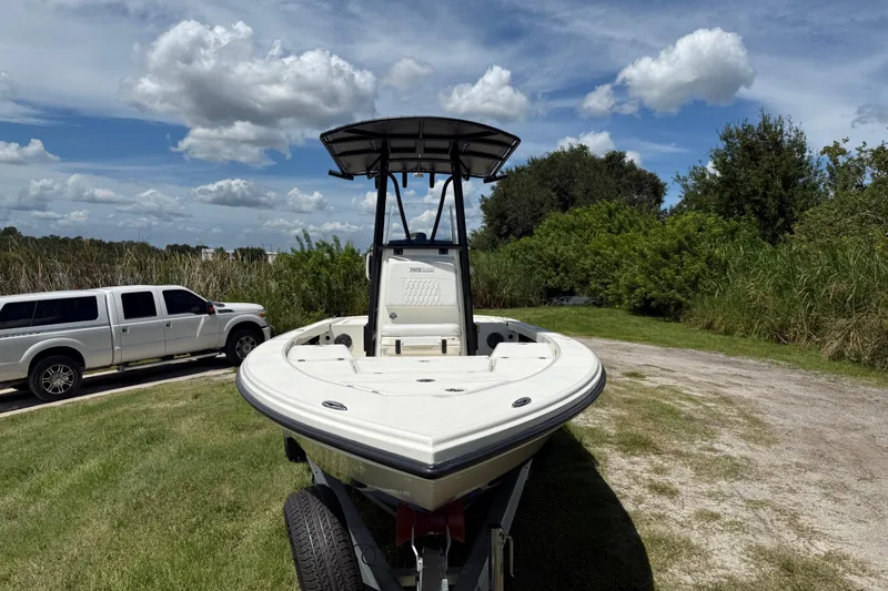 Slide: The Image of 2026 Pathfinder 2300 HPS boat on trailer, parked near white truck, under blue sky. - 11