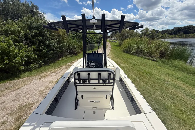 Slide: The Image of 2026 Pathfinder 2300 HPS boat on grassy path by a lake under a blue sky. - 13