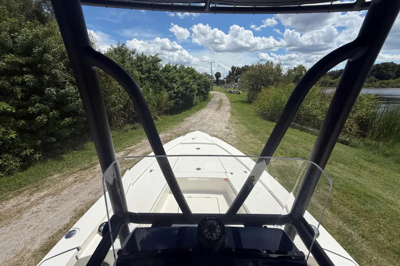 Slide: The Image of Pathfinder 2300 HPS boat on grassy path near water, under a partly cloudy sky. - 16