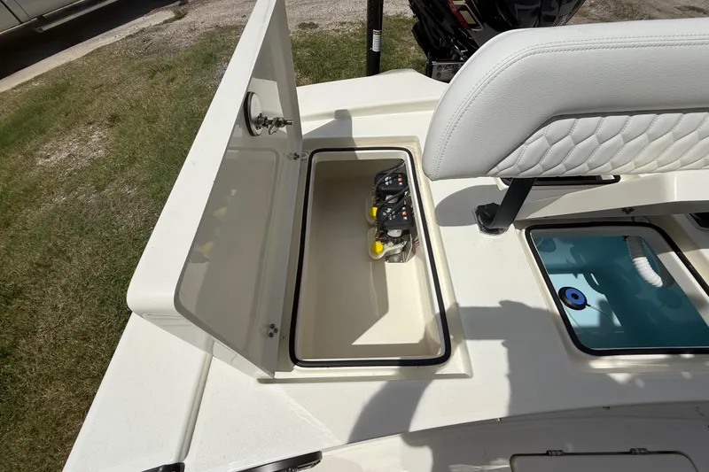 Slide: The Image of 2026 Pathfinder 2300 HPS boat storage compartment with open lid and visible battery switches. - 24