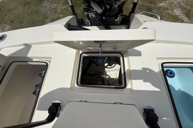 Slide: The Image of 2026 Pathfinder 2300 HPS boat deck with open storage compartments and visible engine components. - 27