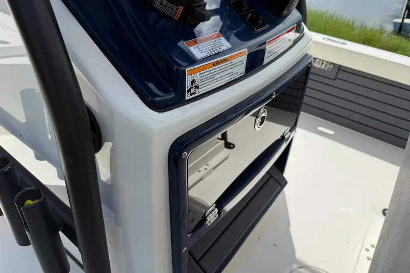Slide: The Image of 2026 Pathfinder 2300 HPS boat console with storage compartment and warning labels. - 31