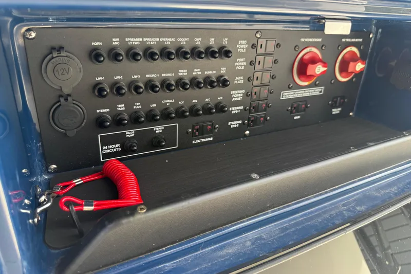 Slide: The Image of Control panel of a 2026 Pathfinder 2300 HPS boat with switches and red safety cord. - 32