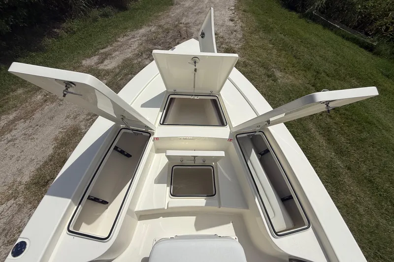 Slide: The Image of 2026 Pathfinder 2300 HPS boat with open storage compartments on a grassy path. - 33