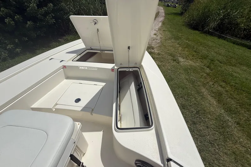 Slide: The Image of 2026 Pathfinder 2300 HPS boat with open storage compartments on a grassy path. - 36