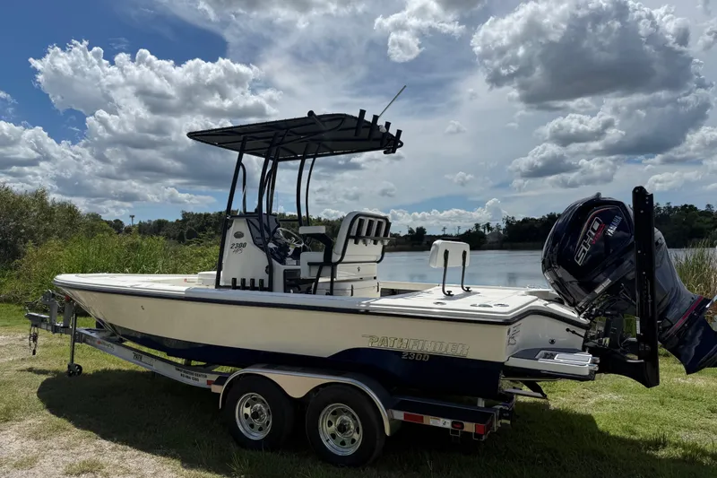 Slide: The Image of 2026 Pathfinder 2300 HPS boat on trailer by a lake under cloudy sky. - 7