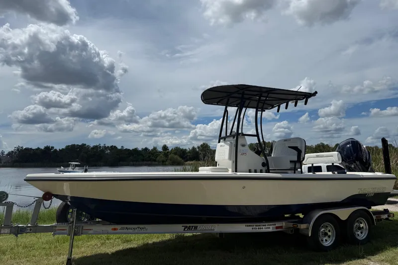 Slide: The Image of 2026 Pathfinder 2300 HPS boat on trailer by a lake under cloudy sky. - 9