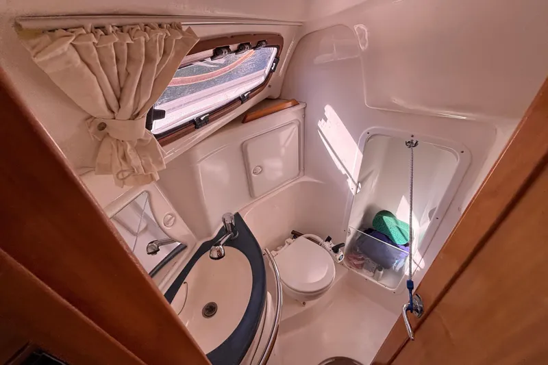 Slide: The Image of Compact bathroom in 2007 Bavaria Cruiser 33 yacht, featuring sink, toilet, and window. - 10
