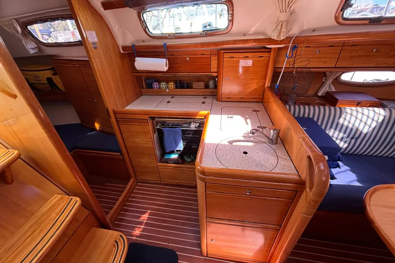 Slide: The Image of Interior of 2007 Bavaria Cruiser 33 yacht with wooden cabinetry and compact kitchen area. - 12