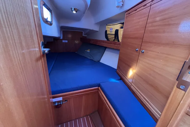 Slide: The Image of Cozy cabin interior of 2007 Bavaria Cruiser 33 with wooden finish and blue bedding. - 15