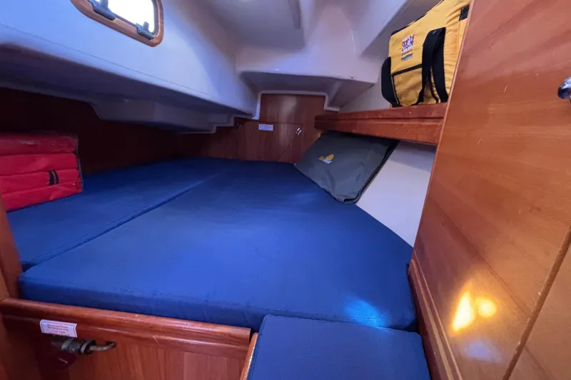 Slide: The Image of 2007 Bavaria Cruiser 33 cabin with blue cushions and wooden storage. - 16