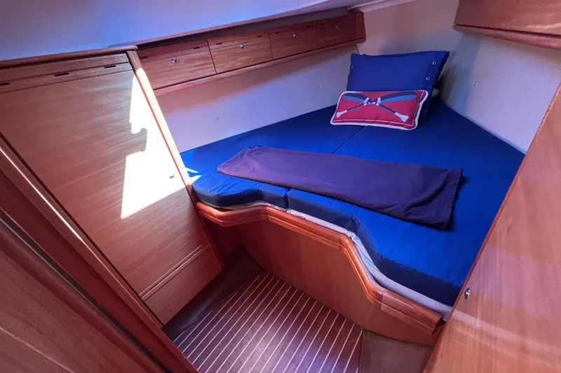 Slide: The Image of Cozy cabin interior of 2007 Bavaria Cruiser 33 sailboat with blue bedding and wooden finish. - 2