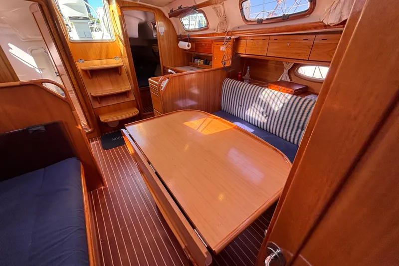 Slide: The Image of Interior of 2007 Bavaria Cruiser 33 sailboat with wooden furnishings and striped seating. - 30