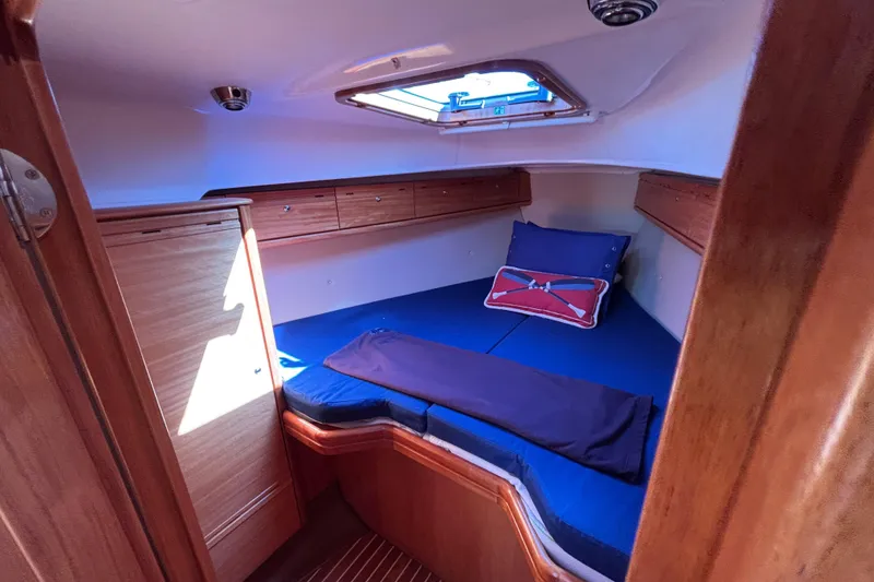 Slide: The Image of Cozy cabin interior of 2007 Bavaria Cruiser 33 sailboat with blue bedding and wooden finish. - 32