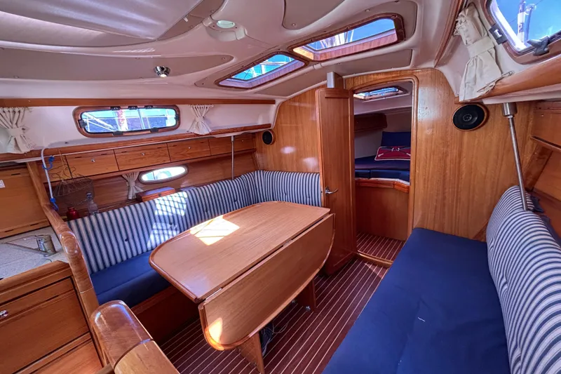 Slide: The Image of Interior of 2007 Bavaria Cruiser 33 sailboat with wood finish and striped seating. - 33