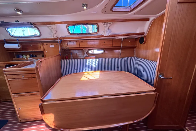 Slide: The Image of Interior of 2007 Bavaria Cruiser 33 sailboat with wooden furnishings and striped seating. - 34