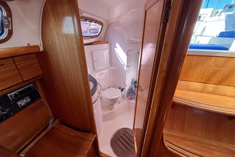 Slide: The Image of Interior of 2007 Bavaria Cruiser 33 yacht, featuring a compact bathroom with wooden finishes. - 9