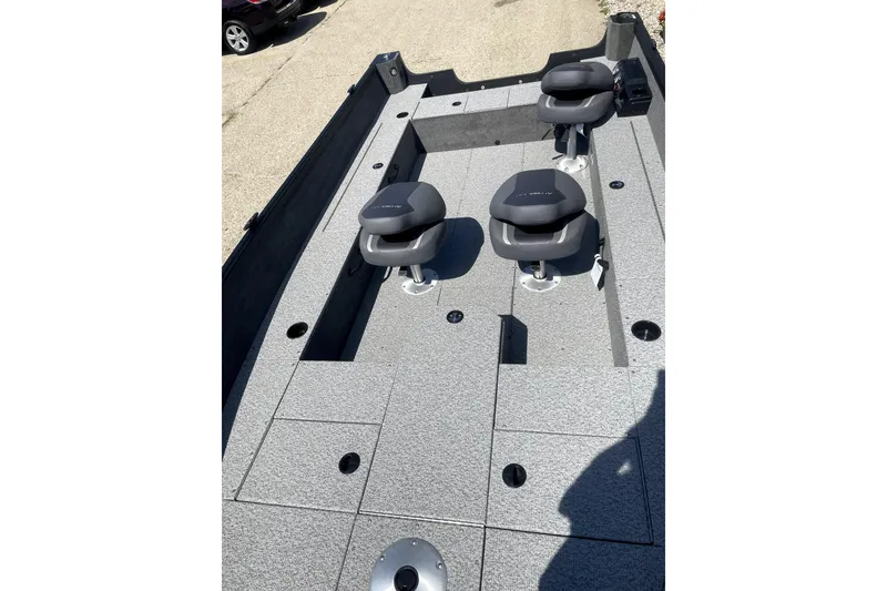 Slide: The Image of 2026 Alumacraft Voyageur 175 Tiller boat interior with two gray seats and storage compartments. - 3