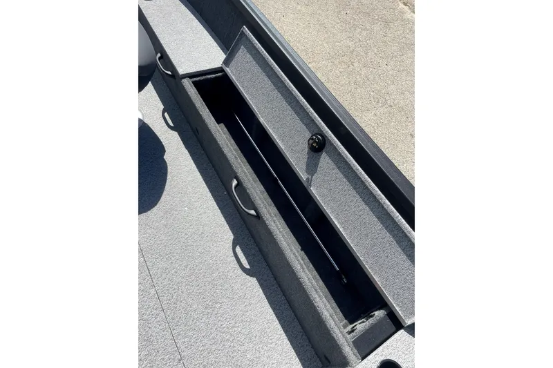Slide: The Image of 2026 Alumacraft Voyageur 175 Tiller boat storage compartment, open and empty. - 9