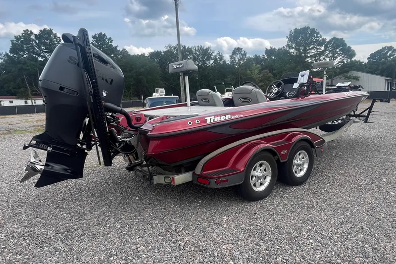 Slide: The Image of 2009 Triton 21X3 Pro DC boat with dual console, parked on gravel lot. - 11
