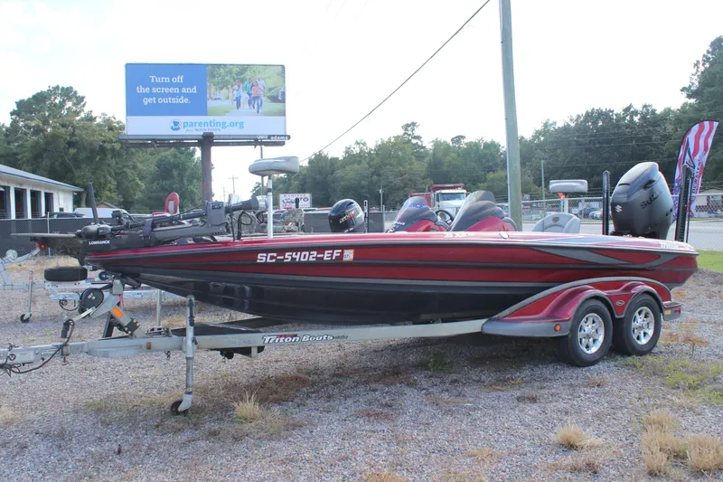 Slide: The Image of 2009 Triton 21X3 Pro DC boat on trailer, parked outdoors near billboard. - 16