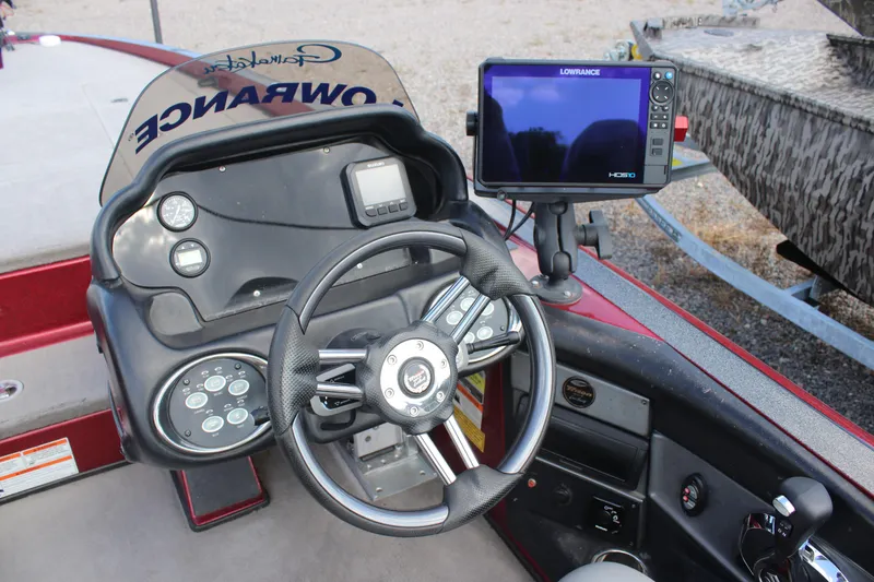 Slide: The Image of 2009 Triton 21X3 Pro DC boat dashboard with steering wheel and Lowrance HDS display. - 21