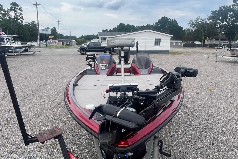 Slide: The Image of 2009 Triton 21X3 Pro DC bass boat in a gravel lot, featuring advanced fishing equipment. - 5