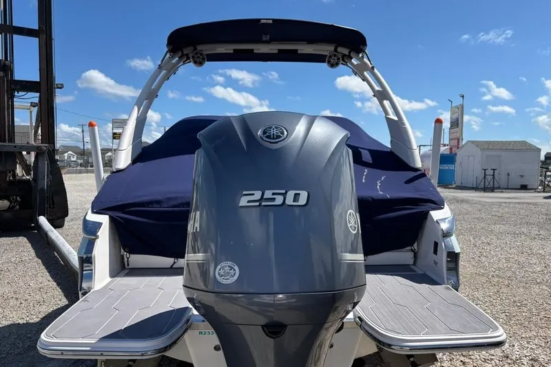 Slide: The Image of 2023 Regal LX4 boat with Yamaha 250 outboard engine, docked under clear blue sky. - 2