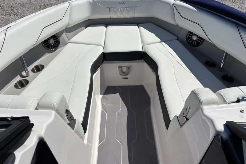 Slide: The Image of 2023 Regal LX4 boat interior with white seating, cup holders, and speakers. - 3