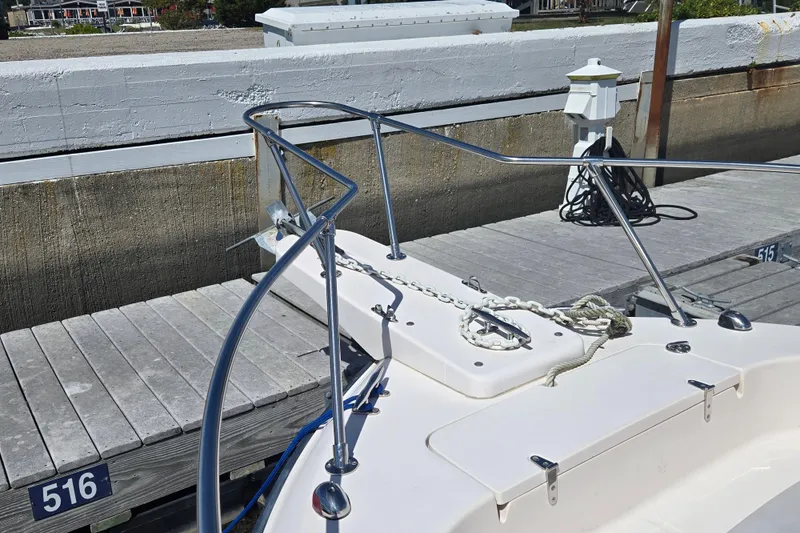 Slide: The Image of 2004 Grady-White Journey 258 boat docked, showing anchor and deck details. - 3