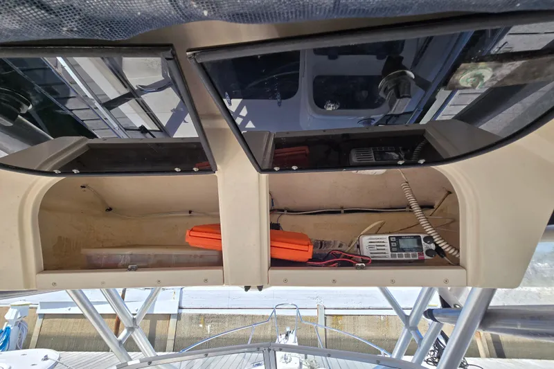 Slide: The Image of 2004 Grady-White Journey 258 boat dashboard with storage compartments and communication equipment. - 5