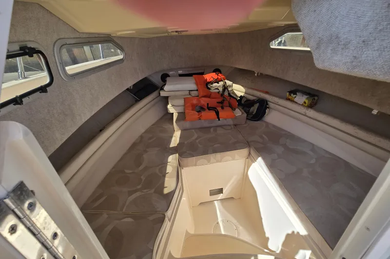 Slide: The Image of 2004 Grady-White Journey 258 cabin interior with seating and life jackets. - 6