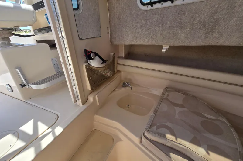 Slide: The Image of 2004 Grady-White Journey 258 boat interior with sink and seating area. - 8