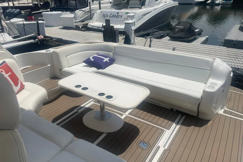 Slide: The Image of 2001 Sea Ray 460 Sundancer yacht interior with white seating and nautical-themed cushions. - 7