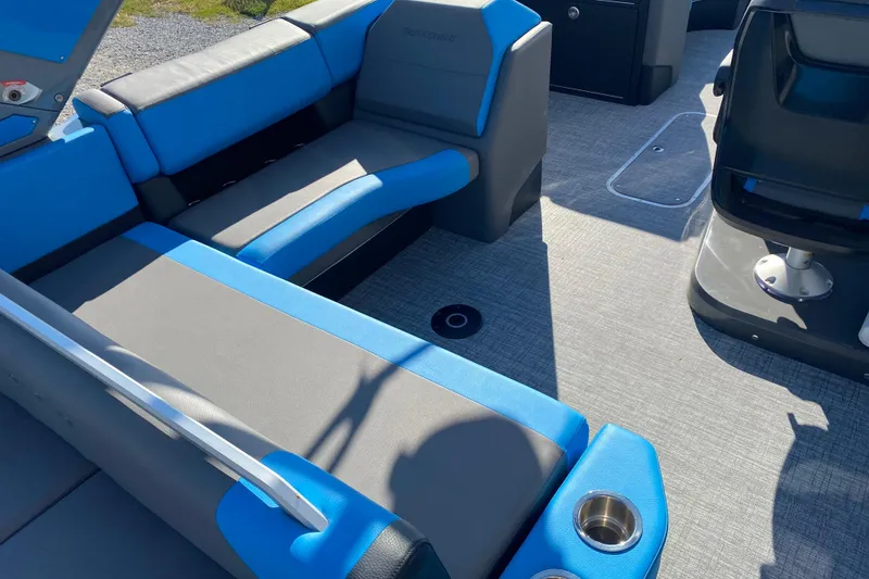 Slide: The Image of 2023 Berkshire 23UL boat interior with blue and gray seating, cup holders, and modern design. - 10