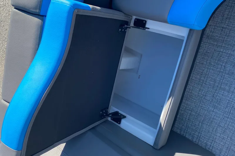 Slide: The Image of Open storage compartment in 2023 Berkshire 23UL boat with blue and gray seating. - 18