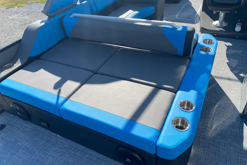 Slide: The Image of 2023 Berkshire 23UL boat interior with blue and gray seating and cup holders. - 7