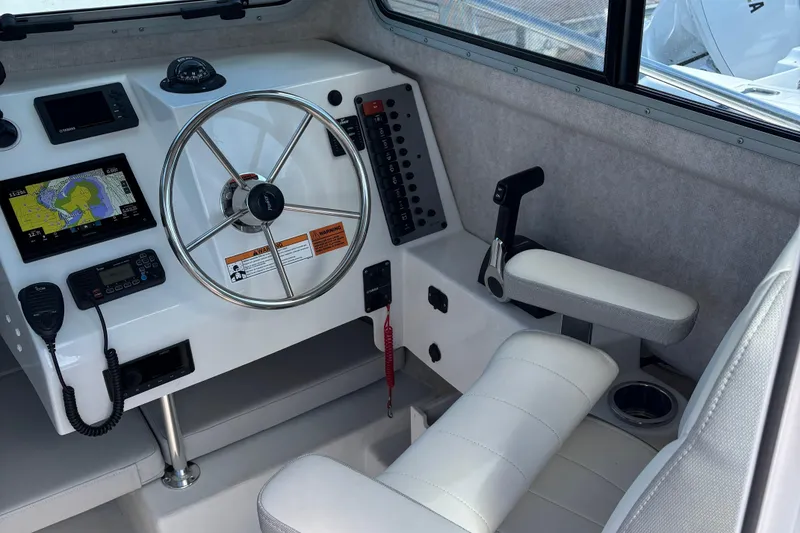Slide: The Image of Interior of 2022 Parker 2120 Sport Cabin boat with steering wheel and navigation equipment. - 4