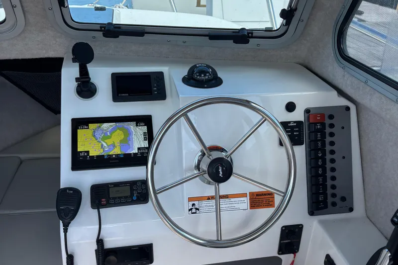 Slide: The Image of 2022 Parker 2120 Sport Cabin dashboard with steering wheel, navigation, and control panels. - 5