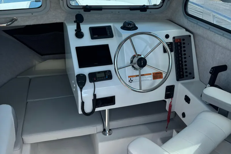Slide: The Image of 2022 Parker 2120 Sport Cabin boat interior with steering wheel and control panel. - 6
