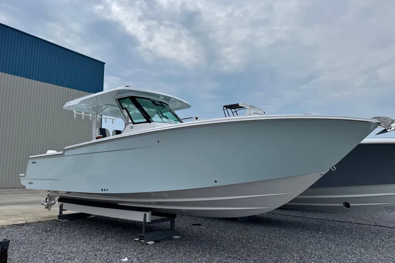 The Image of 2026 Bertram 34CC boat on display, sleek design, parked outdoors under cloudy sky. - 1