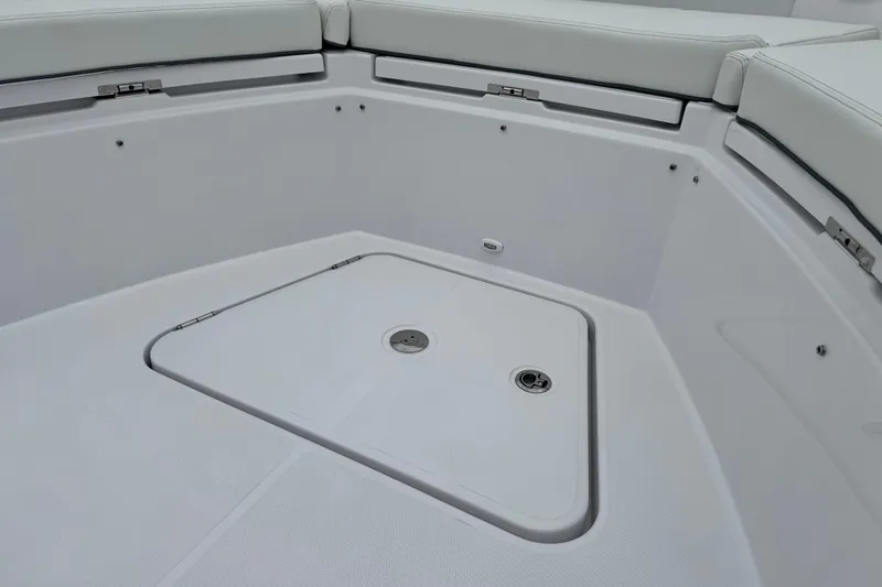 Slide: The Image of 2026 Bertram 34CC boat interior with storage compartment and cushioned seating. - 13