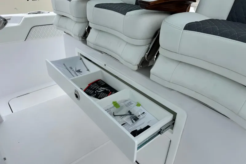 Slide: The Image of 2026 Bertram 34CC boat interior with open storage drawer under cushioned seats. - 24