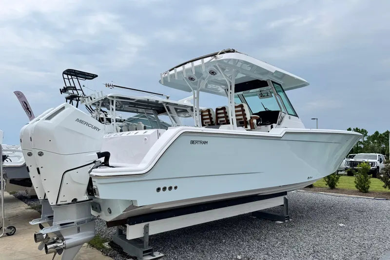 Slide: The Image of 2026 Bertram 34CC boat with dual Mercury engines on display outdoors. - 3